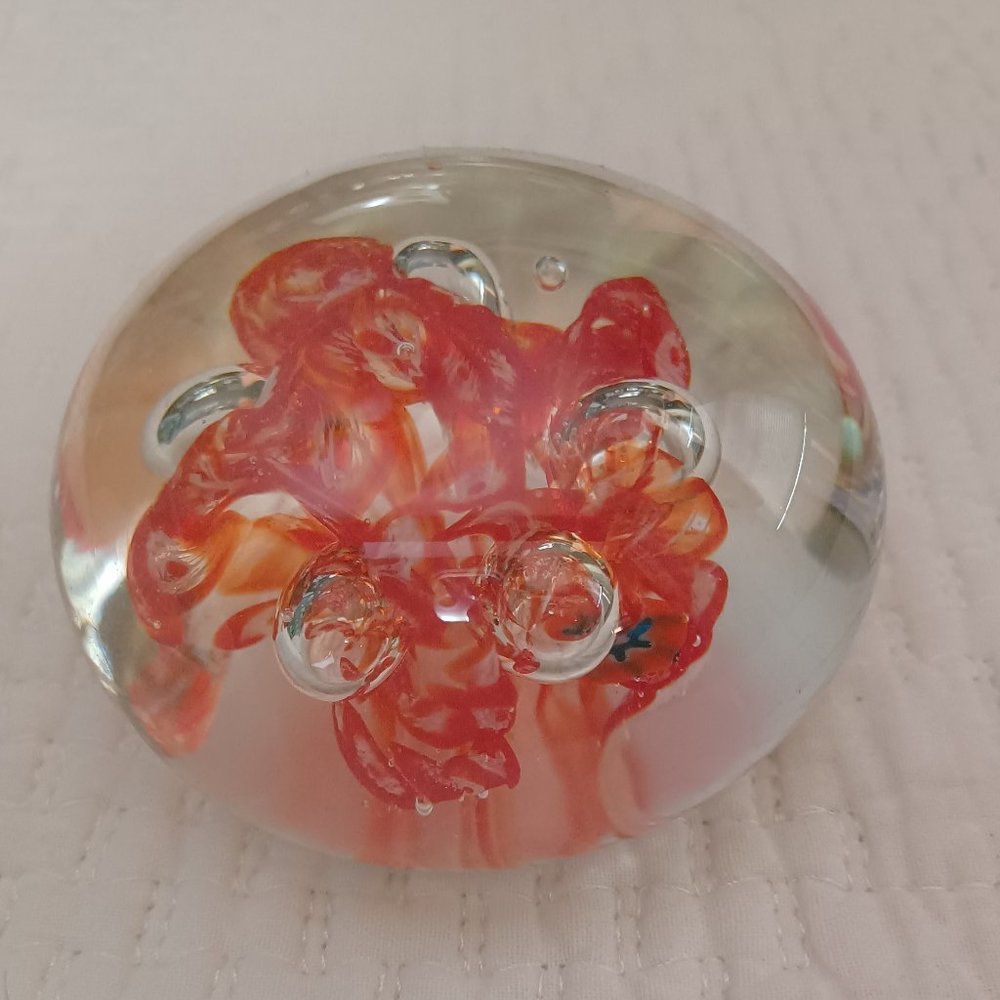 Glass paper-weight with orange reddish flowerlike swirl
